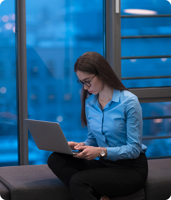 Professional woman working on a laptop in a modern office environment